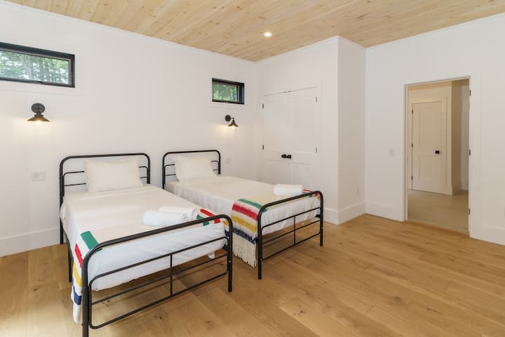 غرفة نوم مشرقة ومتجددة الهواء مع سريرين متماثلين، مثالية لقضاء عطلة مريحة. استمتع بالضوء الطبيعي الذي يتدفق من خلال النوافذ والشعور الدافئ للغرفة.




