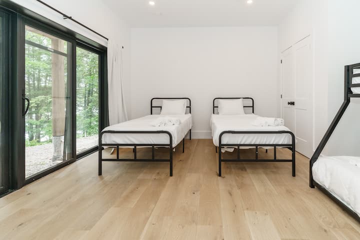 غرفة نوم مشرقة ومتجددة الهواء مع سريرين متماثلين، مثالية لقضاء عطلة مريحة. استمتع بالضوء الطبيعي الذي يتدفق من خلال النوافذ والشعور الدافئ للغرفة.




