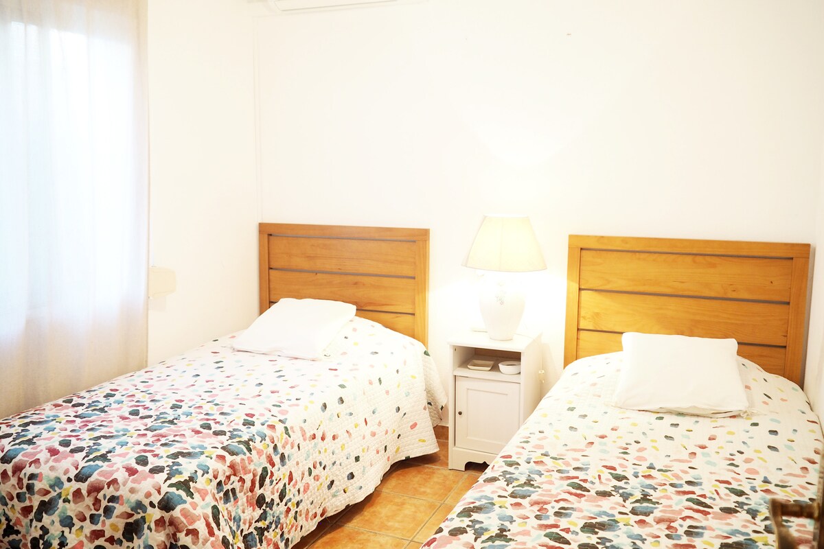 Dormitorio en la planta baja con aire acondicionado y ventilador de techo junto al baño con bañera. Ideal para los niños!