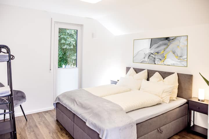 ห้องนอนที่อบอุ่น 2 พร้อมเตียงสปริงคู่ขนาด 180x200 ซม. เก้าอี้นวมชั้นวางตู้เสื้อผ้าโต๊ะข้างเตียง 2 ตัวและโคมไฟข้างเตียง 2 ดวงพร้อมช่องเสียบชาร์จ USB