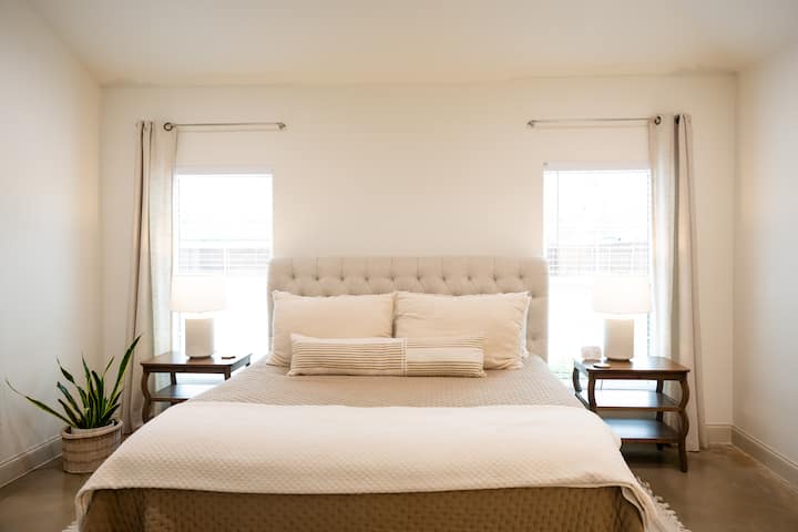 Our master bedroom is located on the ground floor, complete with chargers for your phone and devices. A smart TV is located across from the bed.