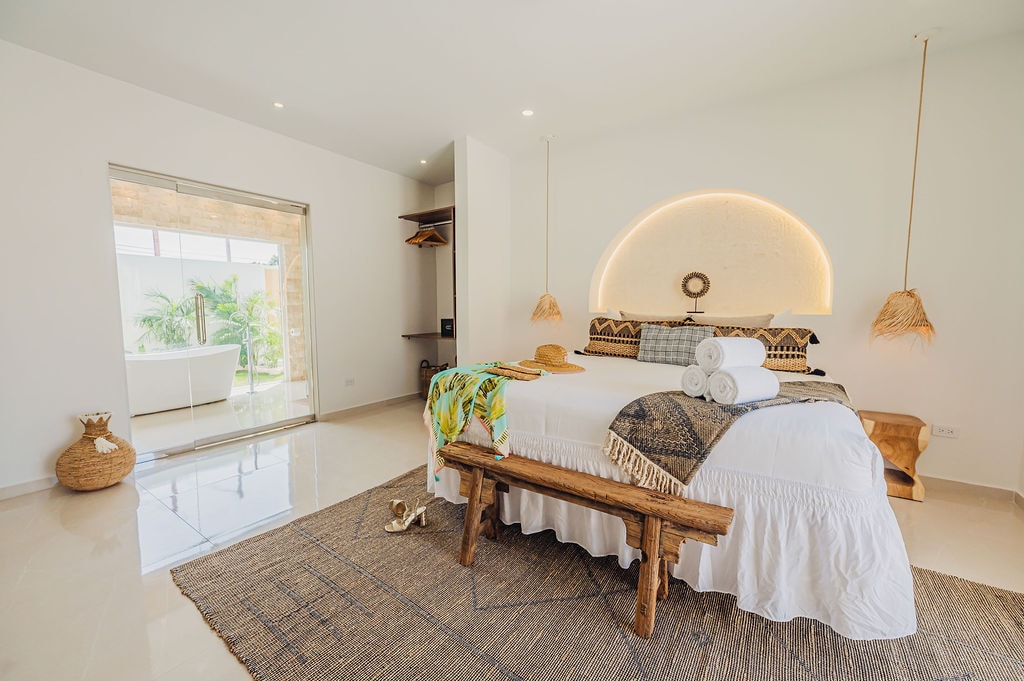 El dormitorio principal cuenta con una cama tamaño king, televisión inteligente LG de 55 pulgadas, armario y baño privado con bañera con vistas a un oasis verde.