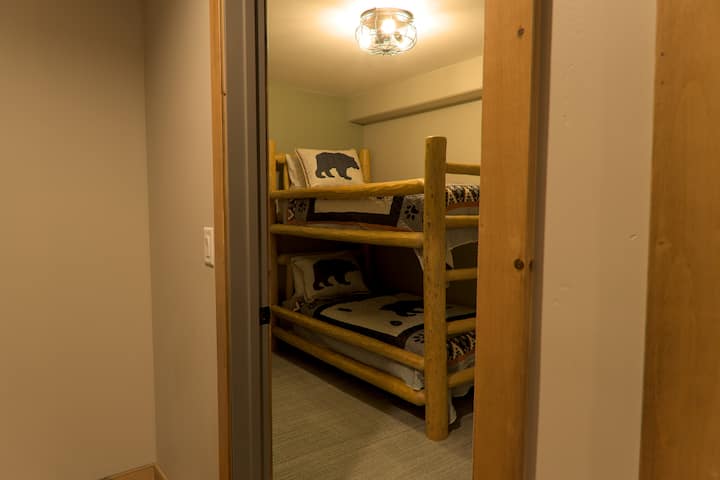 Twin sized bunk beds located in the basement. Across the hall from another bedroom with a full bed and floor mattress.