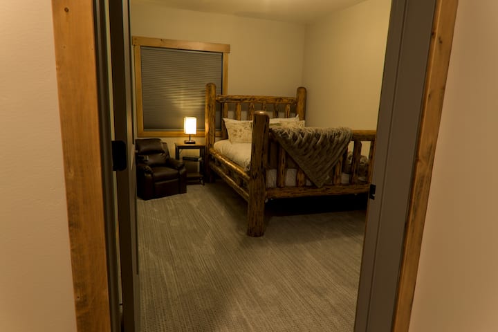 Full sized bed located in the basement along with a twin floor mattress underneath.