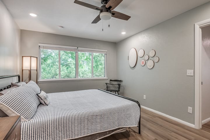 La chambre principale comprend une salle de bain attenante, une grande commode, des barres d'alimentation, des lampes et des tables de chevet des deux côtés du lit, ainsi qu'un miroir pleine longueur, un ventilateur de boîte et des draps et oreillers supplémentaires.