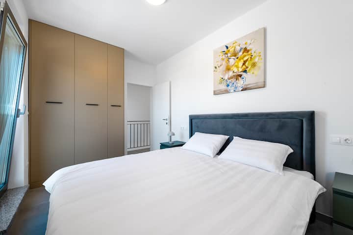 ダブルベッド、エアコン、窓付きの寝室（バルコニーなし）。 自然の概要。電気ブラインド付き。