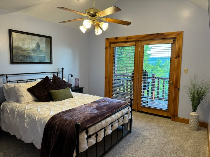 The upstairs "Birdie Suite" has a queen bed, balcony access, smart TV, and an en suite full bathroom with sunken tub and shower.