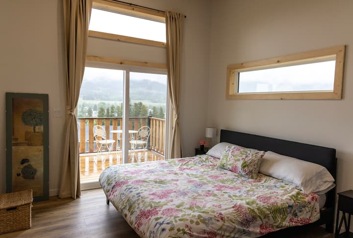 The master bedroom has a king size bed and ensuite bathroom with bathtub.  It has its own door to a private sitting area on the wrap around deck with amazing vistas over the valley and mountains.