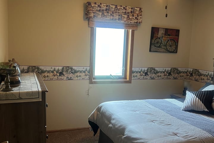 Spavaća soba za goste na katu s komodom.