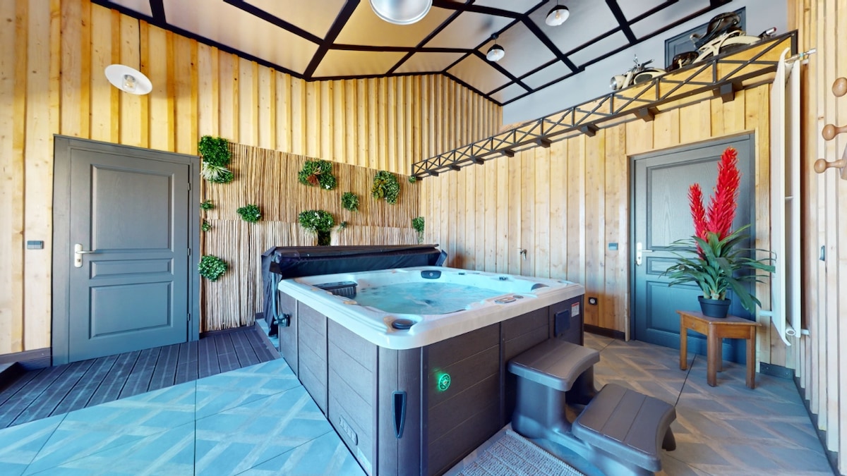 A serene indoor space features a well-equipped Jacuzzi surrounded by wooden paneling and decorative plants. Two doors lead to additional areas, while the flooring showcases a textured pattern. Natural light illuminates the room, creating an inviting ambience for relaxation.