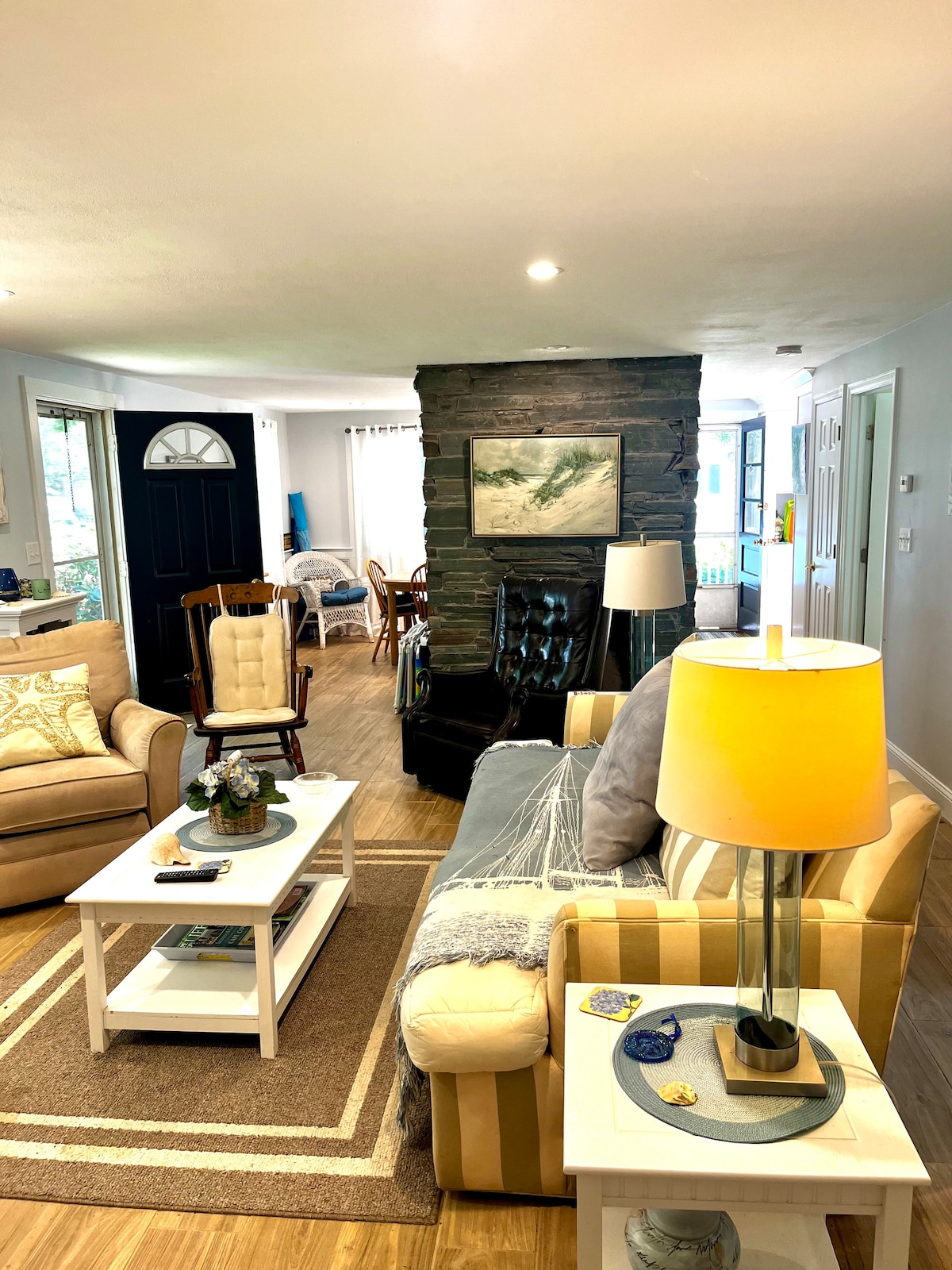 Sebule angavu na yenye hewa safi iliyo na meko na viti vingi vya starehe. 