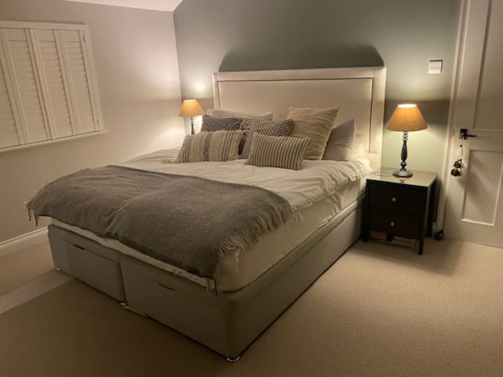 Chumba cha kulala cha kifalme chenye bafu la chumbani. Sehemu nyingi za kuhifadhia kando ya kitanda na nguo, sanduku la blanketi ambalo huongezeka maradufu kama kiti cha dirisha na uhifadhi wa nguo. Kioo cha urefu kamili na kikausha nywele.