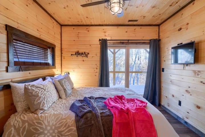 ห้องนอนใหญ่ชั้นล่างพร้อมเตียงขนาดคิงไซส์และอ่างอาบน้ำในตัวพร้อมโต๊ะเครื่องแป้งคู่ฝักบัวอาบน้ำและอ่างอาบน้ำแบบแช่ตัว