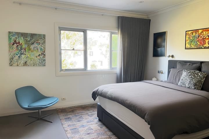 Ნათელი და ფართო მთავარი საძინებელი კომფორტული საწოლითა და გემოვნებიანი დეკორით.