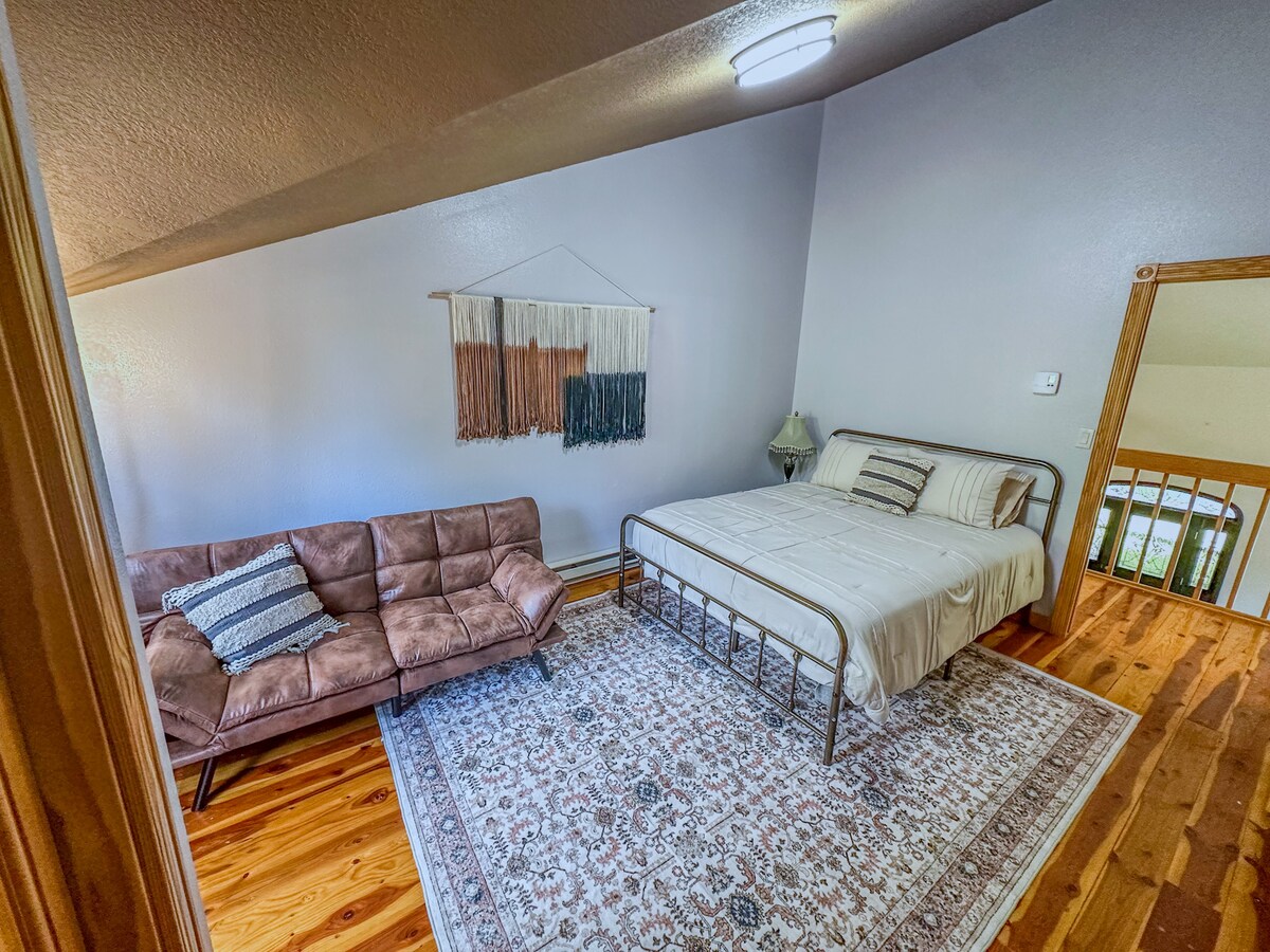 חדר שינה למעלה עם מיטת קווין סייז ופוטון.