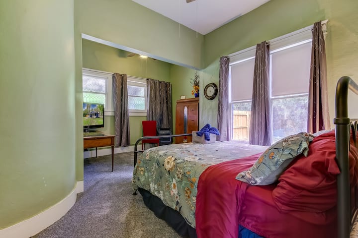The Primary bedroom offers a Queen bed, flat screen TV, a seating area and a desk for remote working. The bedroom has a cozy, cave-like feel when the curtains are closed. The window AC will get this cave cold! 