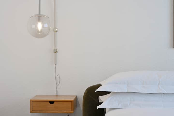 カリカリの白いリネンを備えた豪華なキングサイズベッド、スタイリッシュなペンダント照明、上品なアート作品を備えた穏やかな寝室でリラックスしましょう。 棚が内蔵されており、ゆったりとした夜の睡眠に最適な居心地の良い雰囲気を備えた十分な収納スペースをお楽しみください。