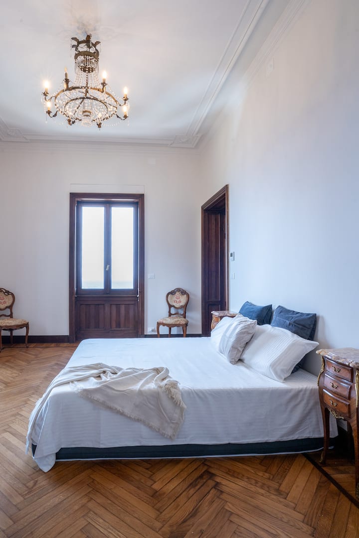 Главна спална соба со 3 одделни прозорци со поглед на море, сопствена бања со када со ногарки, туш со млазен поток, двоен мијалник, плакар, приватен балкон и брачен кревет