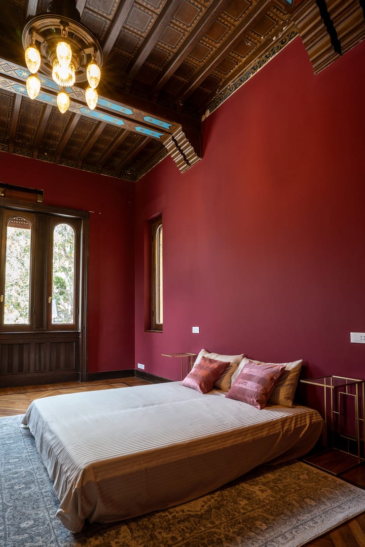 спална соба со украсен фрескоживописен таван и 5 прозорци со поглед на море