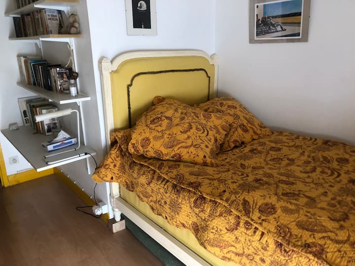 La chambre jaune avec un lit simple