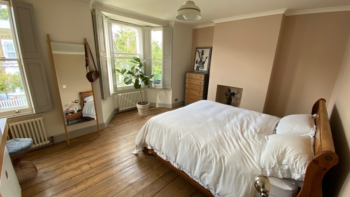 Chumba kikubwa cha kulala chenye kitanda kikubwa na makabati ya bespoke.