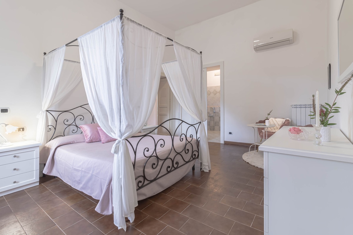 صورة أخرى للغرفة الوردية، حيث يمكنك رؤية غرفة المعيشة والحمام الداخلي في الخلفية.