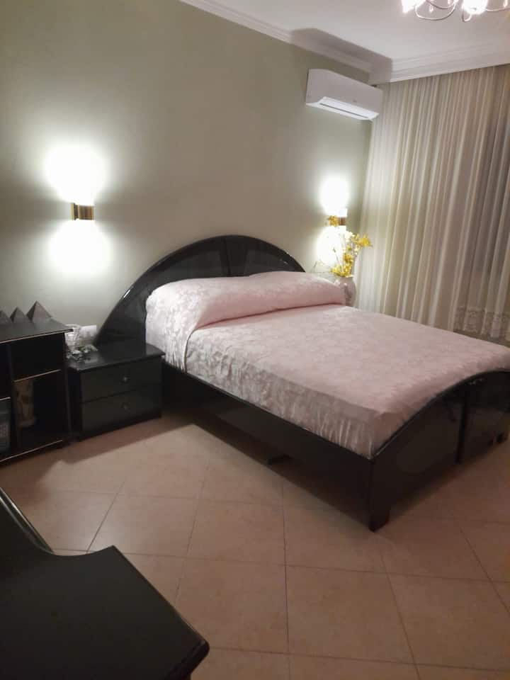 Cama doble para 2 personas y un dormitorio espacioso con aire acondicionado y armario grande.