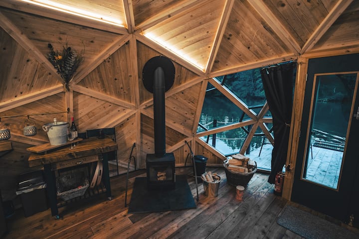 Oheň praská a vôňa dreva sa šíri kupolou. Sledujte odrazy tancujúce na vode vonku – pokojný kokón, kde sa čas spomaľuje a pohodlie prehlbuje.