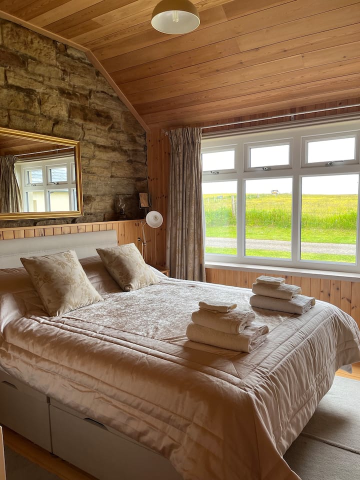 Obiteljska spavaća soba ima veliki bračni krevet, krevete na kat i kameni zid. Ugrađeni je ormar s dovoljno prostora za odjeću i kovčege.