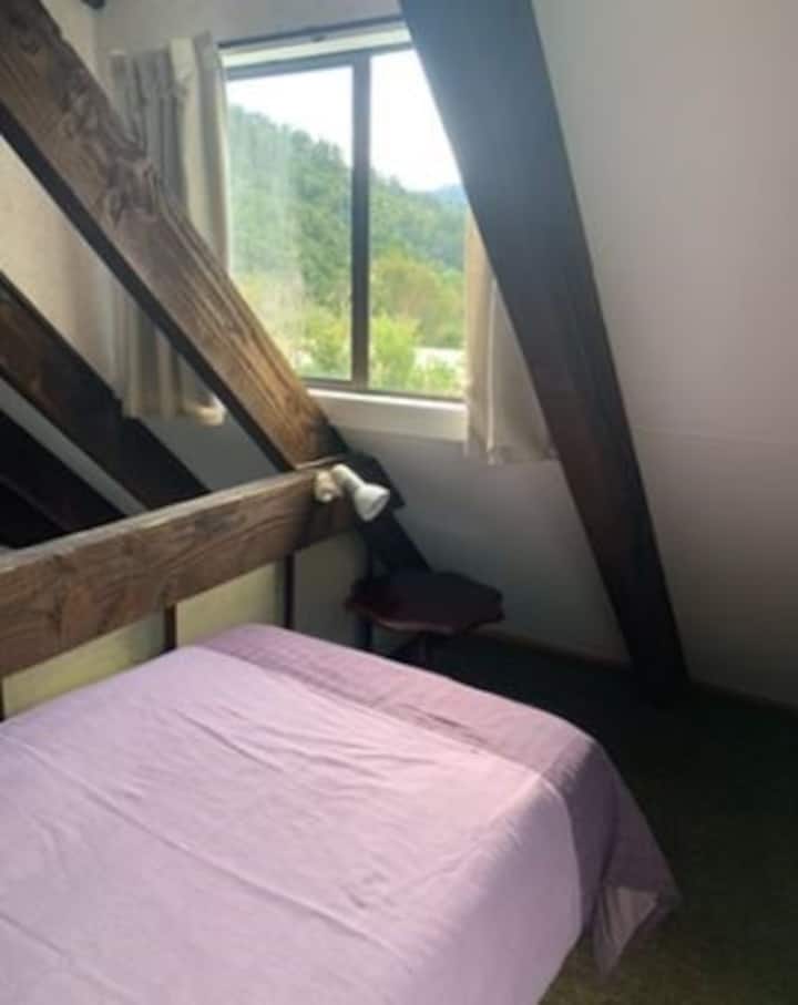 เตียงเดี่ยวในห้องใต้หลังคา การเข้าถึงผ่านบันไดแบบดึงลงในเลานจ์