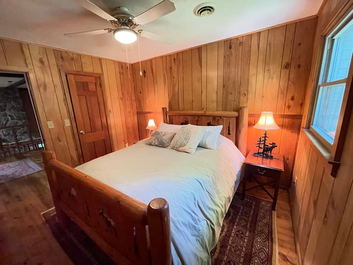 Veľká manželská posteľ s odkladacími stolíkmi na nabíjanie inteligentných telefónov/tabletov.