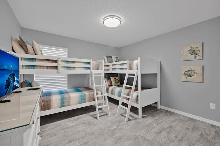Deléitate con la divertida habitación infantil con cuatro literas individuales y un televisor, creando el lugar de reunión perfecto para los jóvenes aventureros en tu escapada a Palm Coast. ¡Ideal para dormir y entretenimiento sin fin!