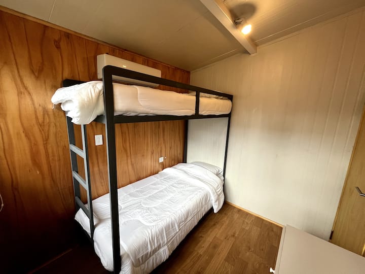 Dos camas singles y abajo una mas que se estira