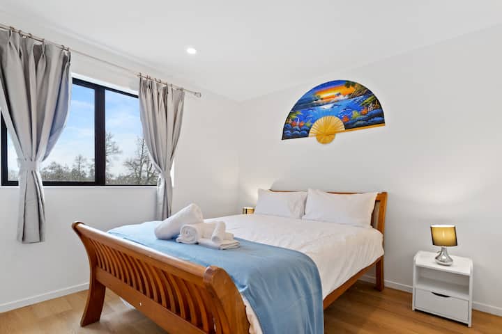 Krevati "Queen" duket tërheqës me çarçafët e tij të bardhë të freskët dhe çarçafët e rehatshëm.