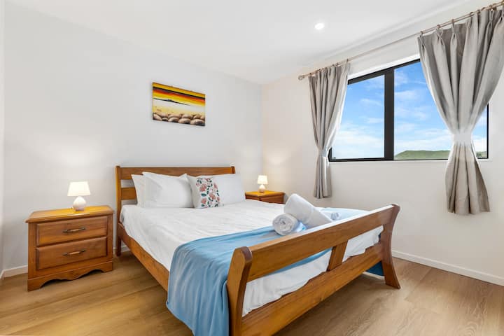 Posteľ Queen vyzerá lákavo s ostrou bielou posteľnou bielizňou a pohodlným prehozom.