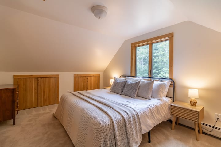 Cómoda cama tamaño king en el dormitorio del loft de arriba