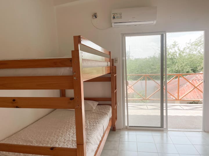 غرفة ساحرة بسرير بطابقين سهل الاستخدام وسرير مزدوج مريح، وتقع في الطابق العلوي مع إمكانية الوصول إلى شرفة خاصة للاسترخاء في الهواء الطلق.