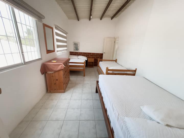 غرفة ساحرة بسرير فردي مريح وسريرين مزدوجين مريحين، تقع في الطابق العلوي للخصوصية، وهي مثالية للمجموعات الصغيرة أو العائلات التي تبحث عن الراحة والمساحة.