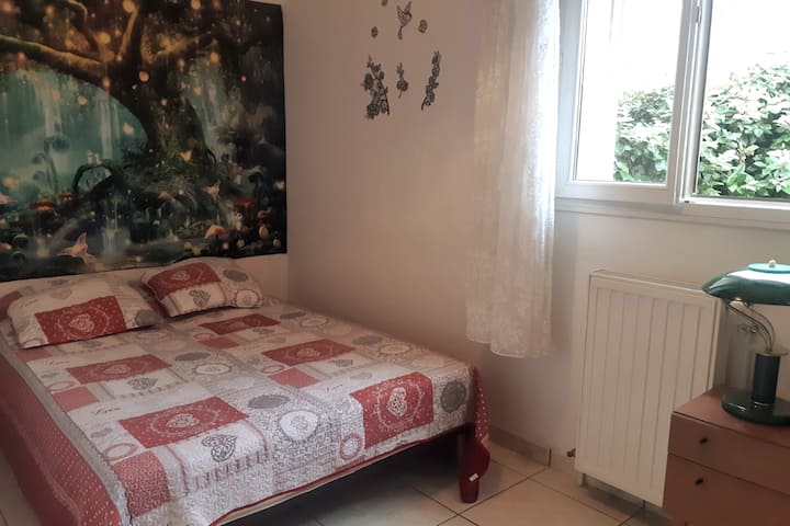 Chambre 4 avec tapisserie murale "l'Arbre Magique" et comportant un lit de 1,40m, une petite commode et sa lampe de chevet et un très grand placard de rangement.