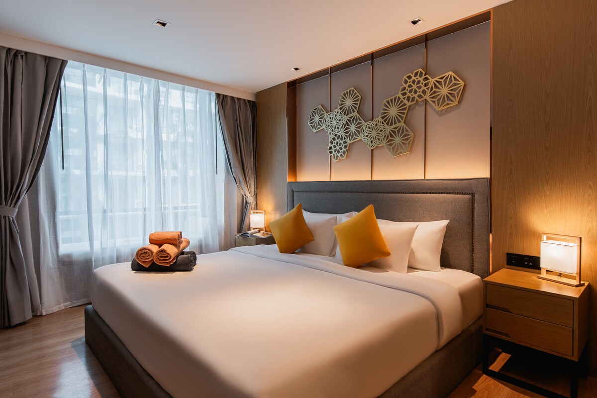 Просторна спалня с първокласно спално бельо и меко осветление.
