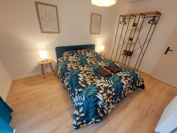 Chambre reposante avec un lit double confortable et des décorations douces créant une atmosphère apaisante. Un endroit idéal pour une nuit de sommeil réparateur, avec des couleurs calmes et un cadre relaxant pour se ressourcer.