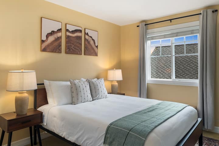 Chumba cha 2 cha kulala cha Mgeni chenye dirisha linaloelekea Kusini.  Chumba hiki kina kitanda cha ukubwa wa malkia chenye starehe kilicho na meza zilizo na maduka ya umeme yanayofaa na bandari za kuchaji za USB.  Kioo kamili kiko ukutani.  Madirisha yana mapazia yanayozuia mwanga.