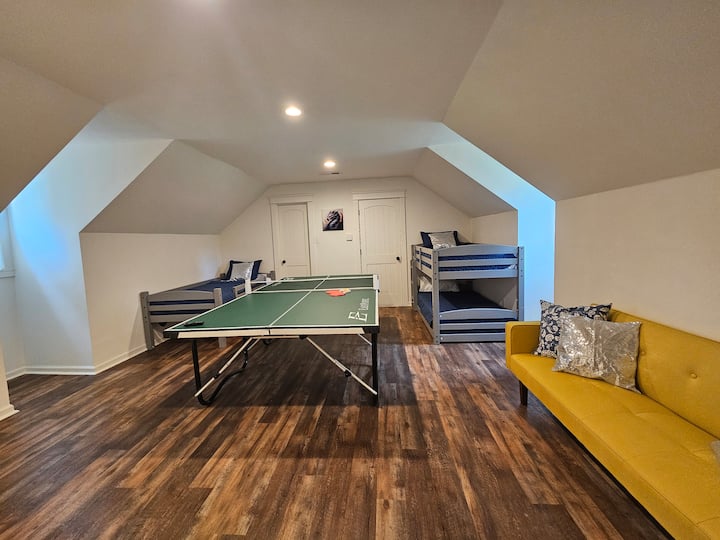 Detská izba s tromi poschodovými posteľami, rozkladacou pohovkou a stolným tenisom. 