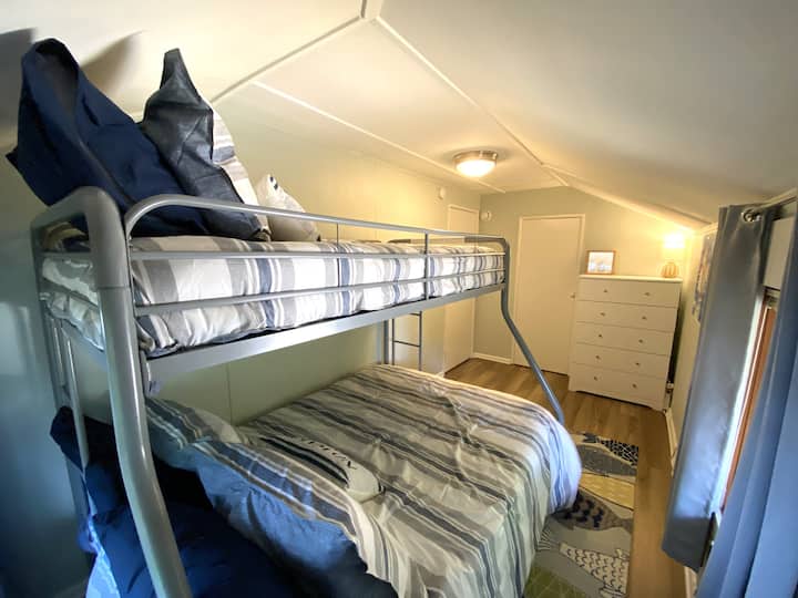 Cette chambre avec lit superposé dispose d'un lit jumeau en haut et d'un double en bas avec une échelle à chaque extrémité du lit, parfaite pour les enfants ou les invités supplémentaires. Une grande commode et un placard offrent un espace de rangement supplémentaire pour les valises et les vêtements.