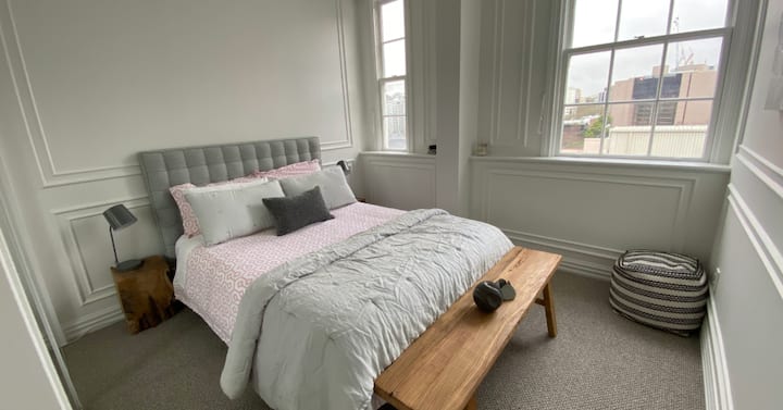 غرفة النوم الثانية هي ملاذ مصمم بعناية، يجمع بين الأناقة الرقيقة مع الإضاءة الطبيعية الوافرة والمساحة المرنة - مثالية للضيوف كملاذ مريح.