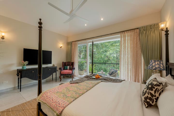 Bustani ya hali ya juu iliyo na kitanda cheusi chenye mabango manne kama kitovu, kilichokamilishwa na lafudhi za pastel. Televisheni kubwa ya inchi 55 iko kwenye koni nzuri, inayofaa kwa usiku wa sinema wenye starehe. Roshani ya kujitegemea inatoa mwonekano tulivu wa kijani kibichi.