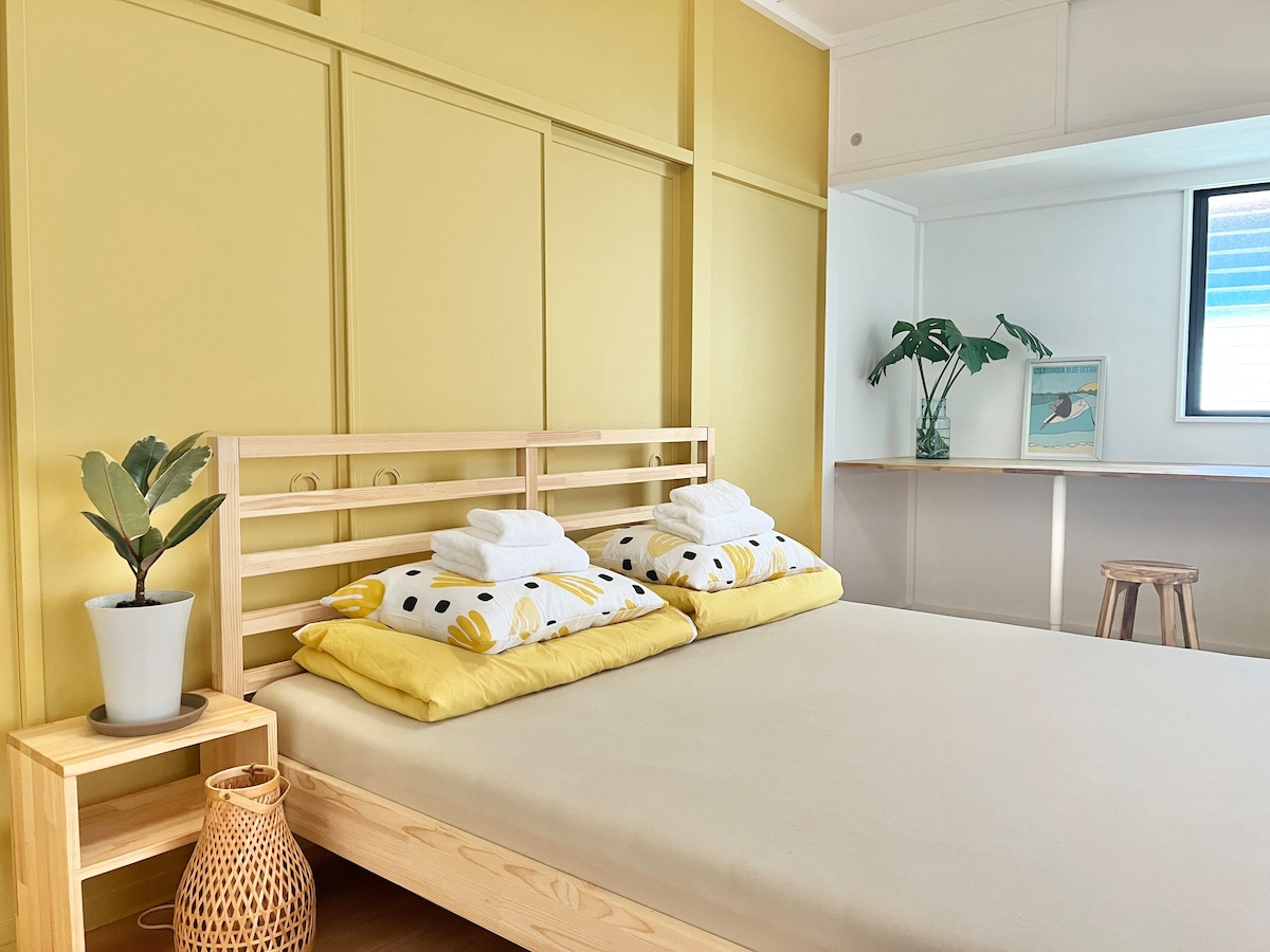 Slaapkamer op de 1e verdieping met een queensize bed, een groot bureau en een kledingkast. 