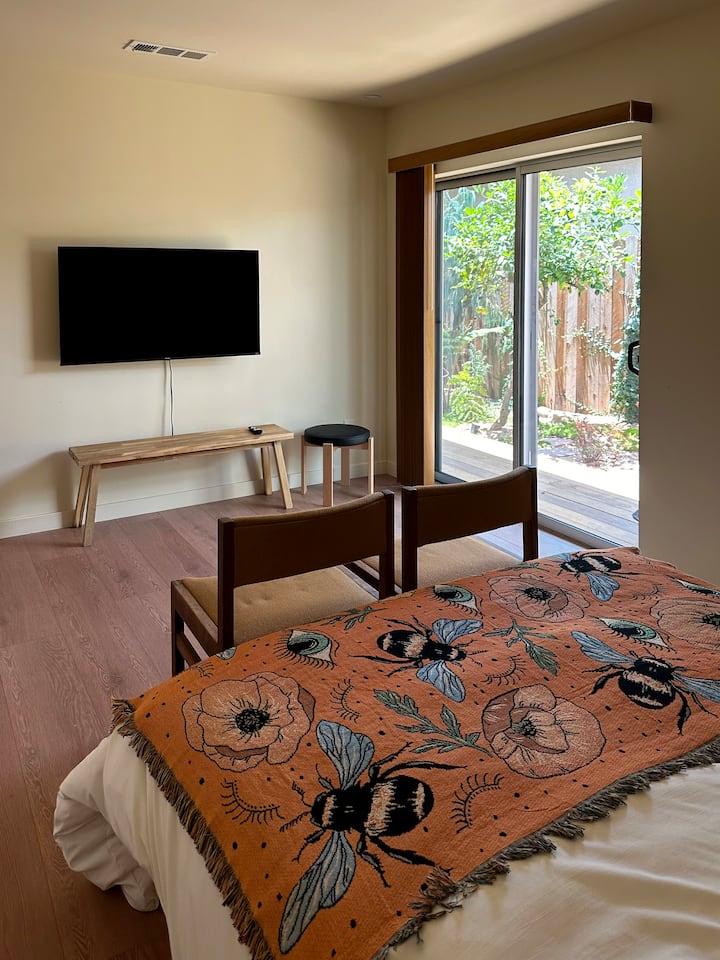 Ova svijetla, minimalistički uređena spavaća soba ima izlaz u privatni vrt, a u njoj se nalazi televizor pričvršćen za zid, jednostavna drvena klupa i udoban krevet prekriven šarenim prekrivačem s uzorkom pčela. Mirno mjesto za uživanje u prijenosu sadržaja, drijemanju ili sunčanju samo nekoliko koraka od kreveta.