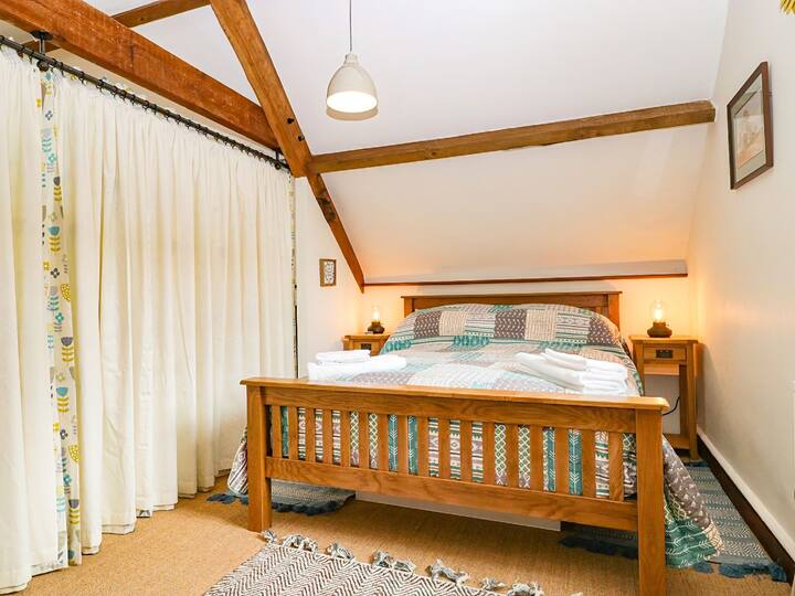 Quarto 1. Cama de madeira confortável king size, guarda-roupa, cômoda. Por favor, observe que este é um espaço aberto e separado por cortinas de teatro.