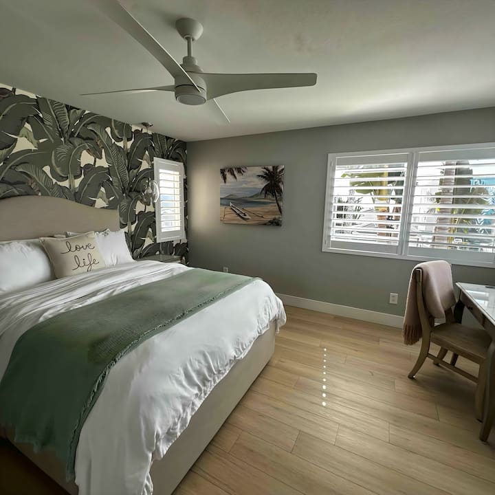 Главна спална соба со сопствена бања.  Вклучува паметен телевизор на ѕид и маса за шминкање или биро за секретар.